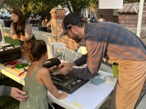Child learning how to screenprint from a screenprinter