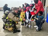 Firefighter interacting with a family at Public Safety Day